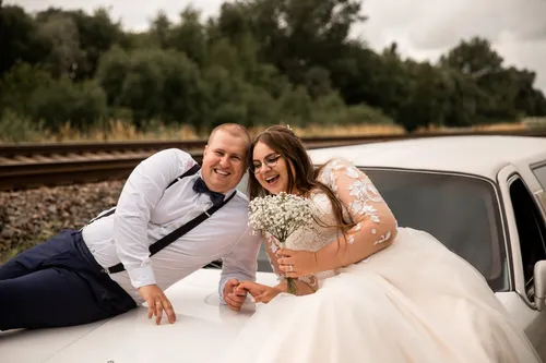 Jaunieji ant limuzino susikabine rankomis