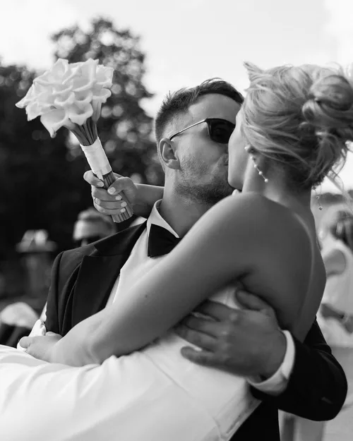 Jaunieji buciuojasi ir nuotaka jaunikio rankose